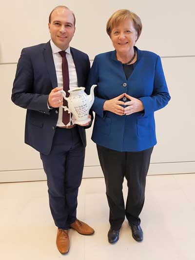 Altkanzlerin Angela Merkel übergibt Florian Oßner im Berliner Reichstag eine signierte Kaffeekanne für eine örtliche Aktion im Rahmen der Kinderkrebshilfe 2019 (Foto: CSU-Niederbayern)