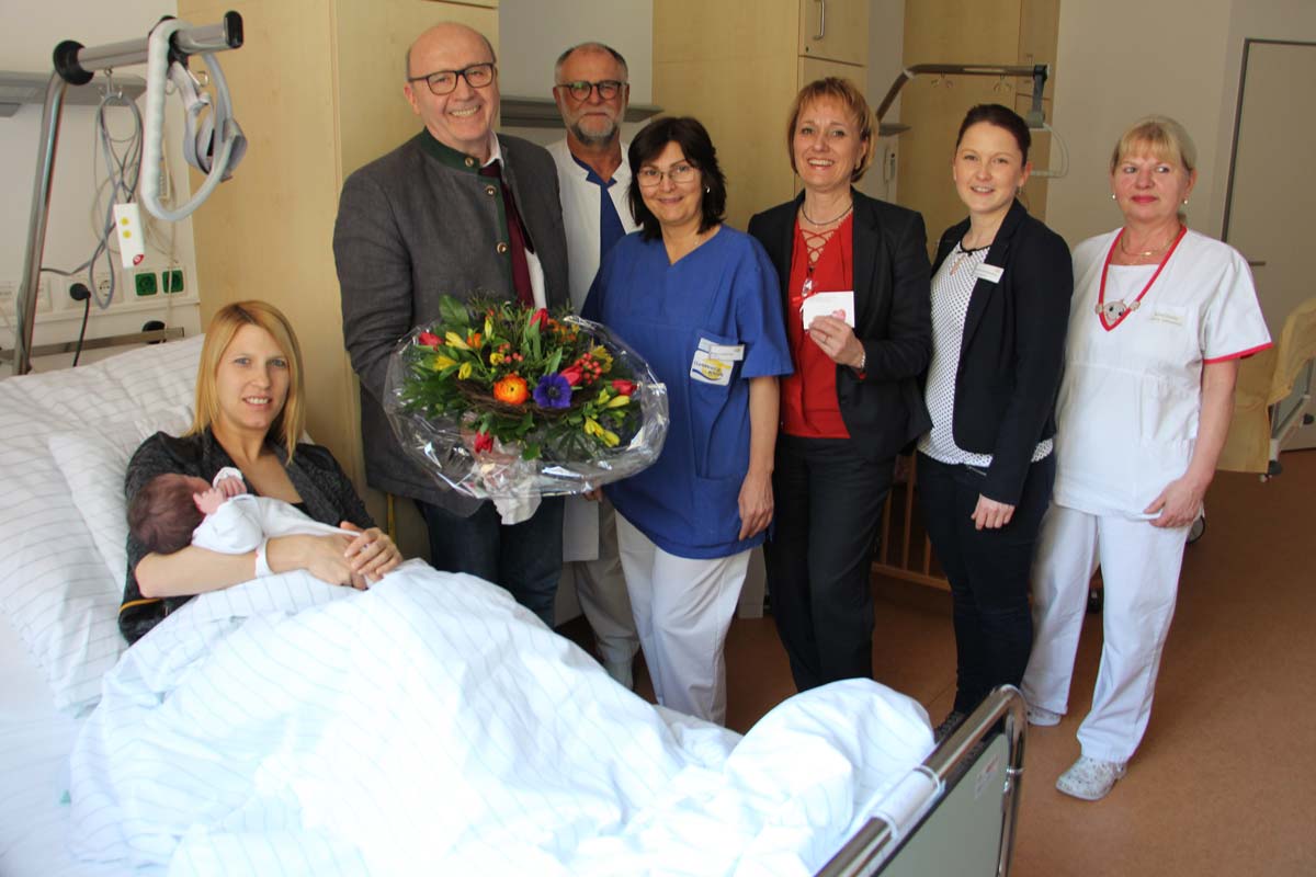 Landrat Martin Neumeyer überreichte Sandra Reim einen Blumenstrauß und gratulierte zum Valentins-Baby Sophia (Foto: Goldberg-Klinik Kelheim)