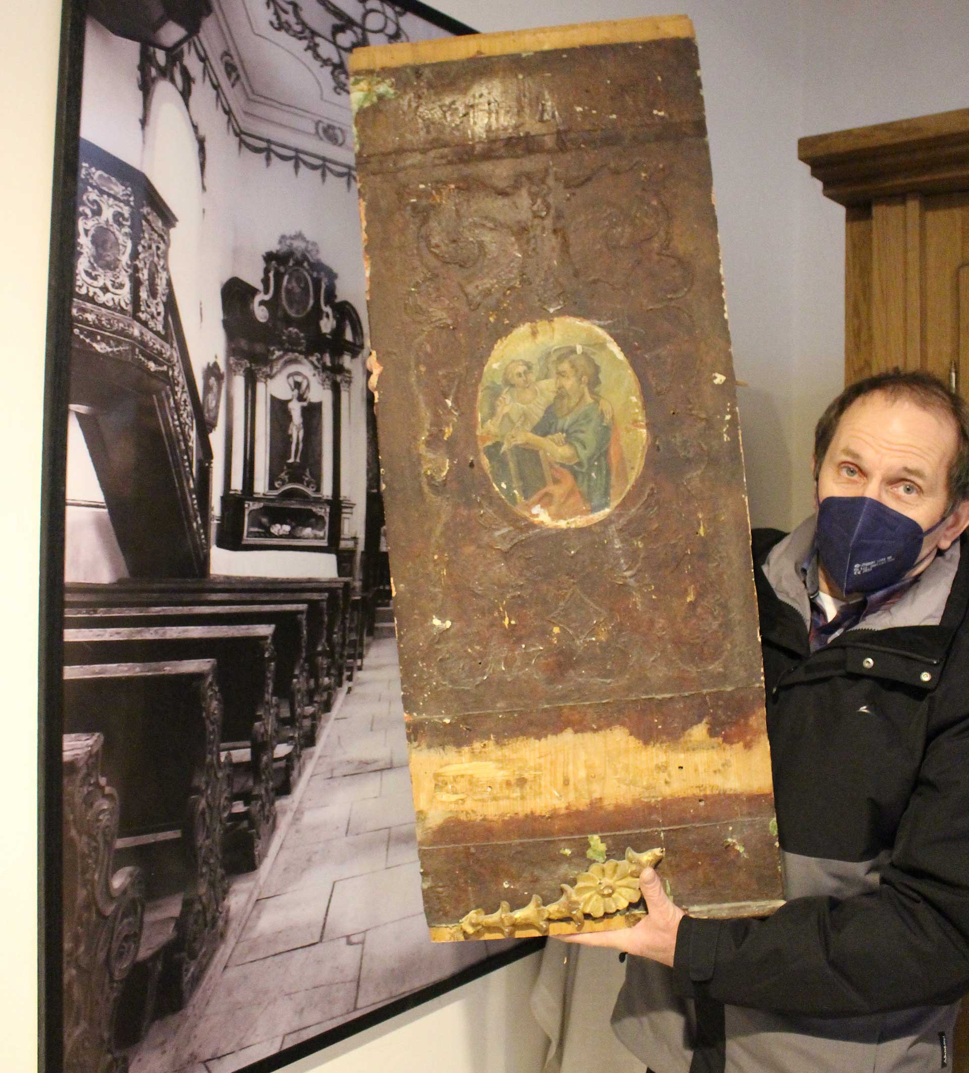 Kirchenpfleger Sebastian Alkofer mit einer der alten Kanzel-Tafeln (Foto: Ingo Knott/Stadt Abensberg)