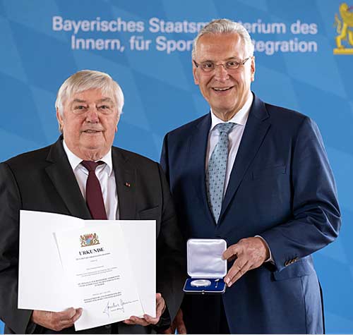Sebastian Hobmeier (links) mit Staatsminister Joachim Herrmann, der ihm die Urkunde mit Medaille überreichte (Foto: Sebastian Widmann/StMi)