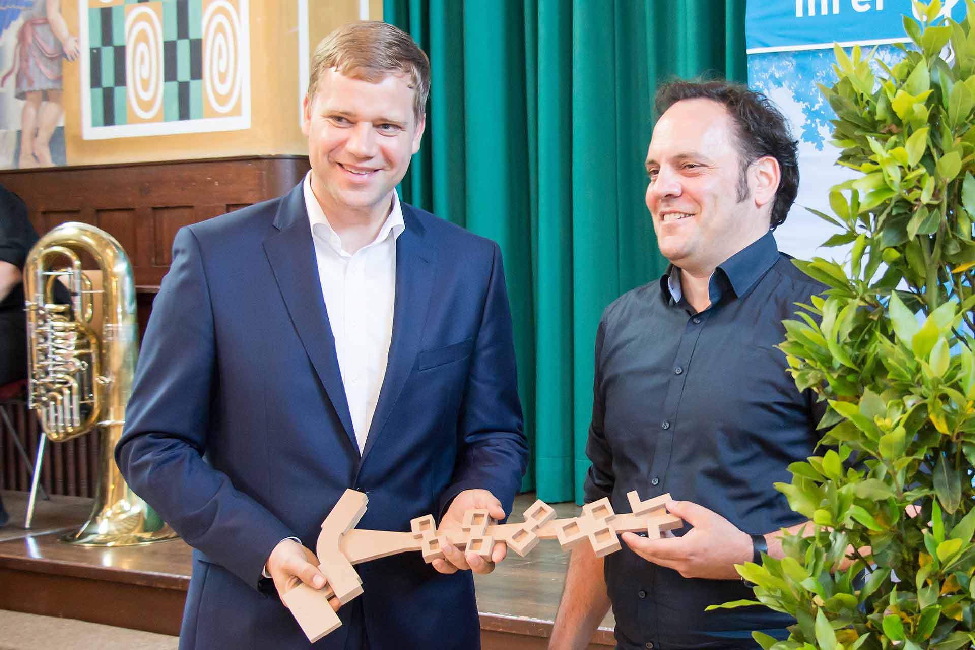 Architekt Jochen Eggert übergibt Bezirkstagspräsident Dr. Olaf Heinrich den symbolischen Schlüssel (Foto: Bezirk Niederbayern/Bäter)