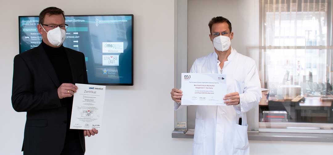 v.l.: Krankenhausdirektor Uwe Böttcher und der Chefarzt des Neurologischen Zentrums Prof. Dr. Schmidt-Wilcke zeigen die beiden Auszeichnungen der Mainkofener Stroke Unit. (Foto: Bezirksklinikum Mainkofen)