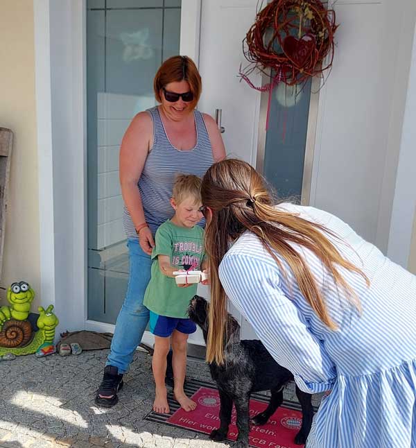 Ramona Eder übergibt ein Kinder-Memory dem Sohn der Familie Hampel (Foto: R. Hampel)