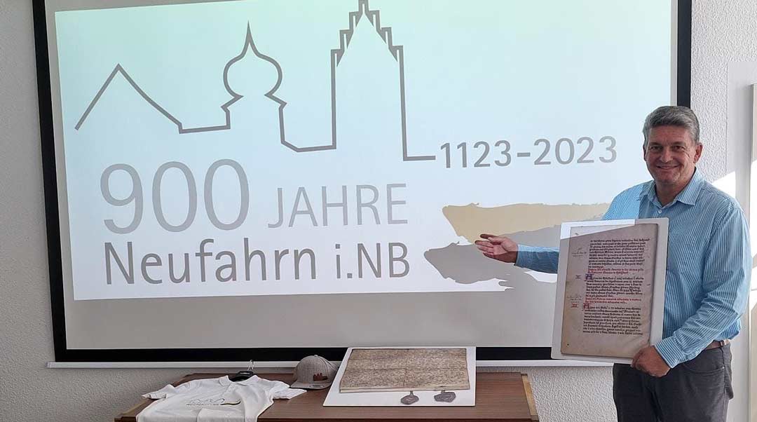 Neufahrns Bürgermeister Peter Forstner freut sich auf die Feierlichkeiten zum 900-jährigen Bestehen von Neufahrn i. Ndb. (Foto: Rathaus Neufahrn/Logo: Franz Sedlmeier)