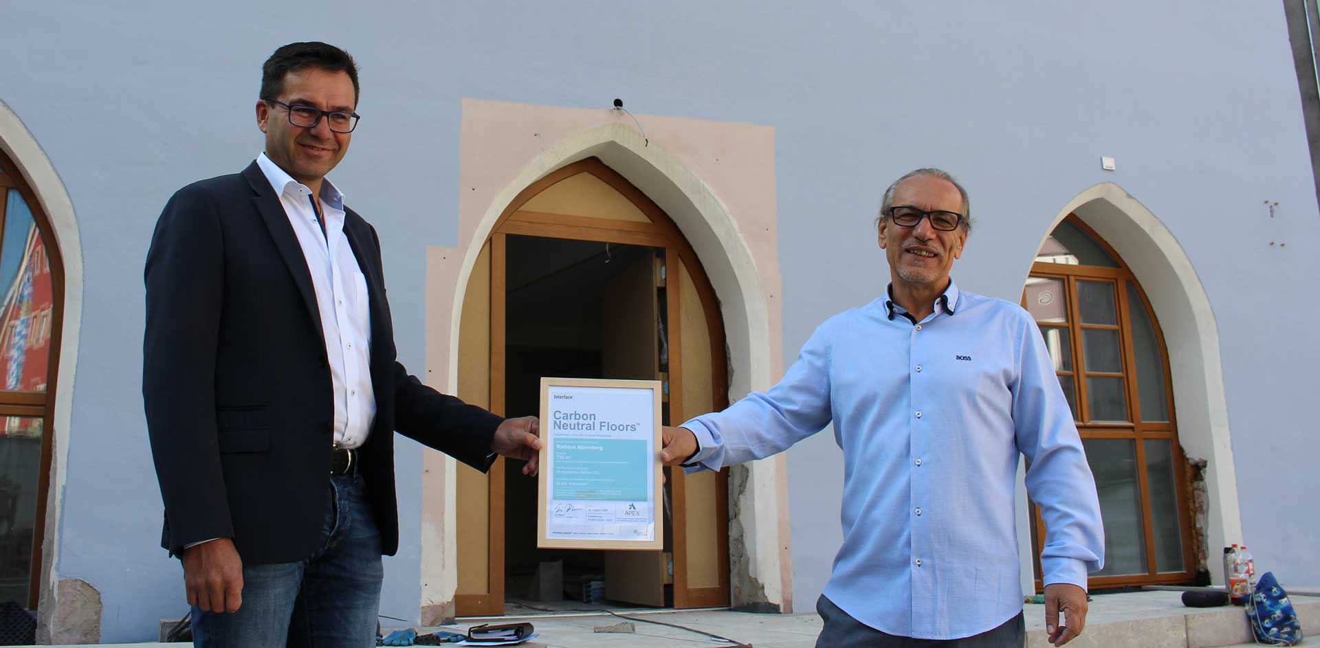 v.l.: Helmut Wichmann und Gerhard Rölz präsentieren vor dem Rathaus das Co2-Zertifikat (Foto: Ingo Knott/Stadt Abensberg)