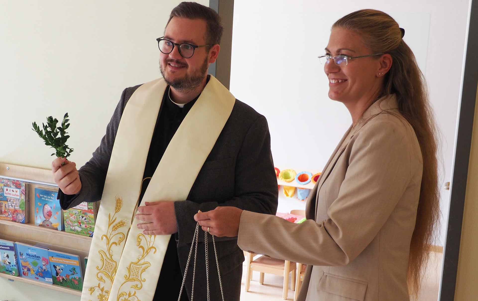 Pfarrer Wolfgang Schillinger und -Minstrantin- Marion Linderer bei der Weihe der neuen Kindertagesstätte (Foto: br-medienagentur)